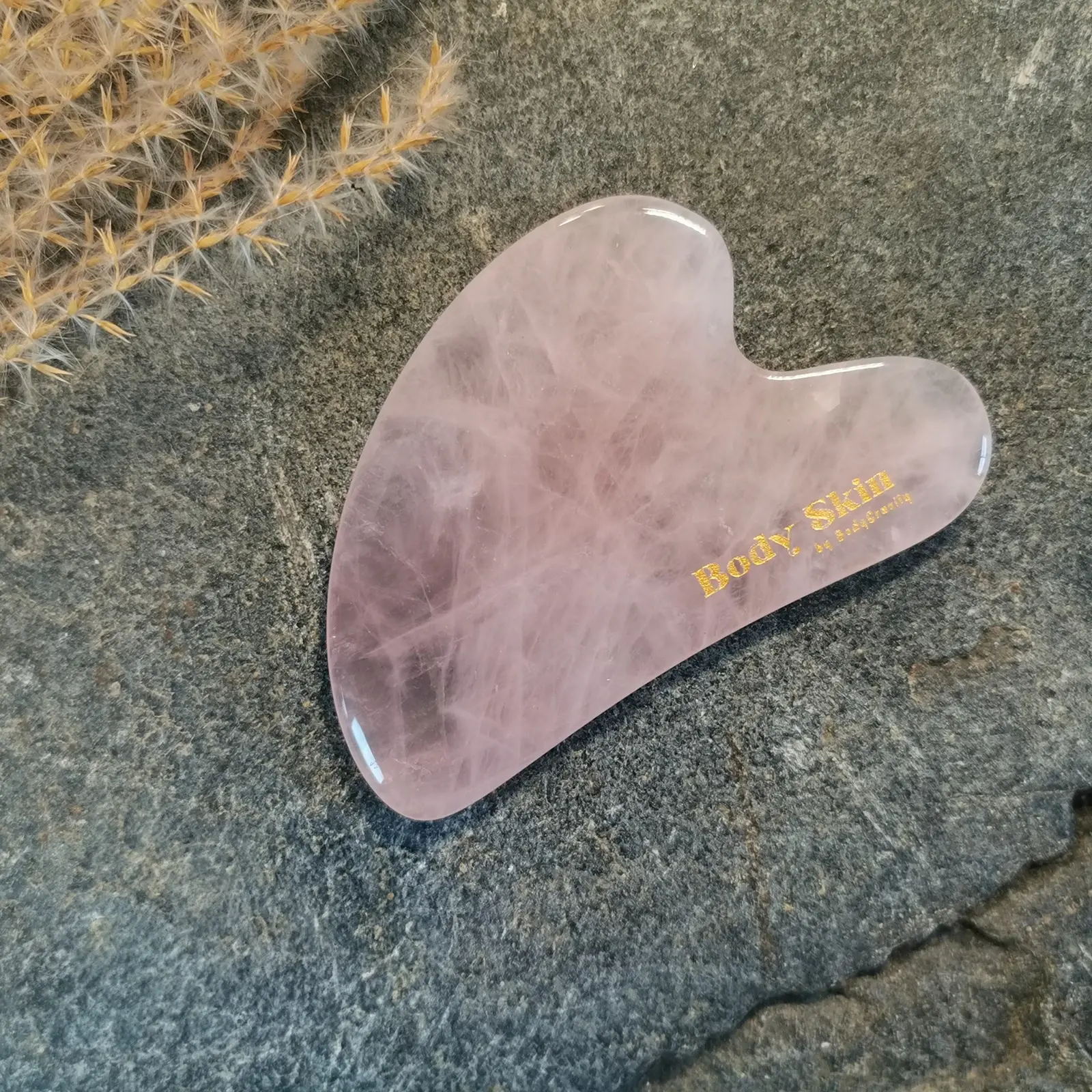 Zoom sur pierre de Gua sha quartz rose sur granit