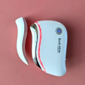 Zoom sur Gua sha électrique Lifty de la marque BodySkin, coloris blanc sur fond rose