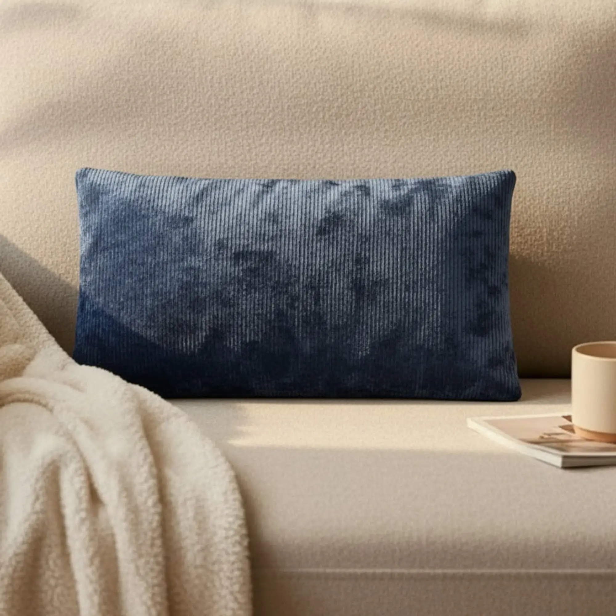 Coussin massant Relaxo bleu posé sur un canapé design