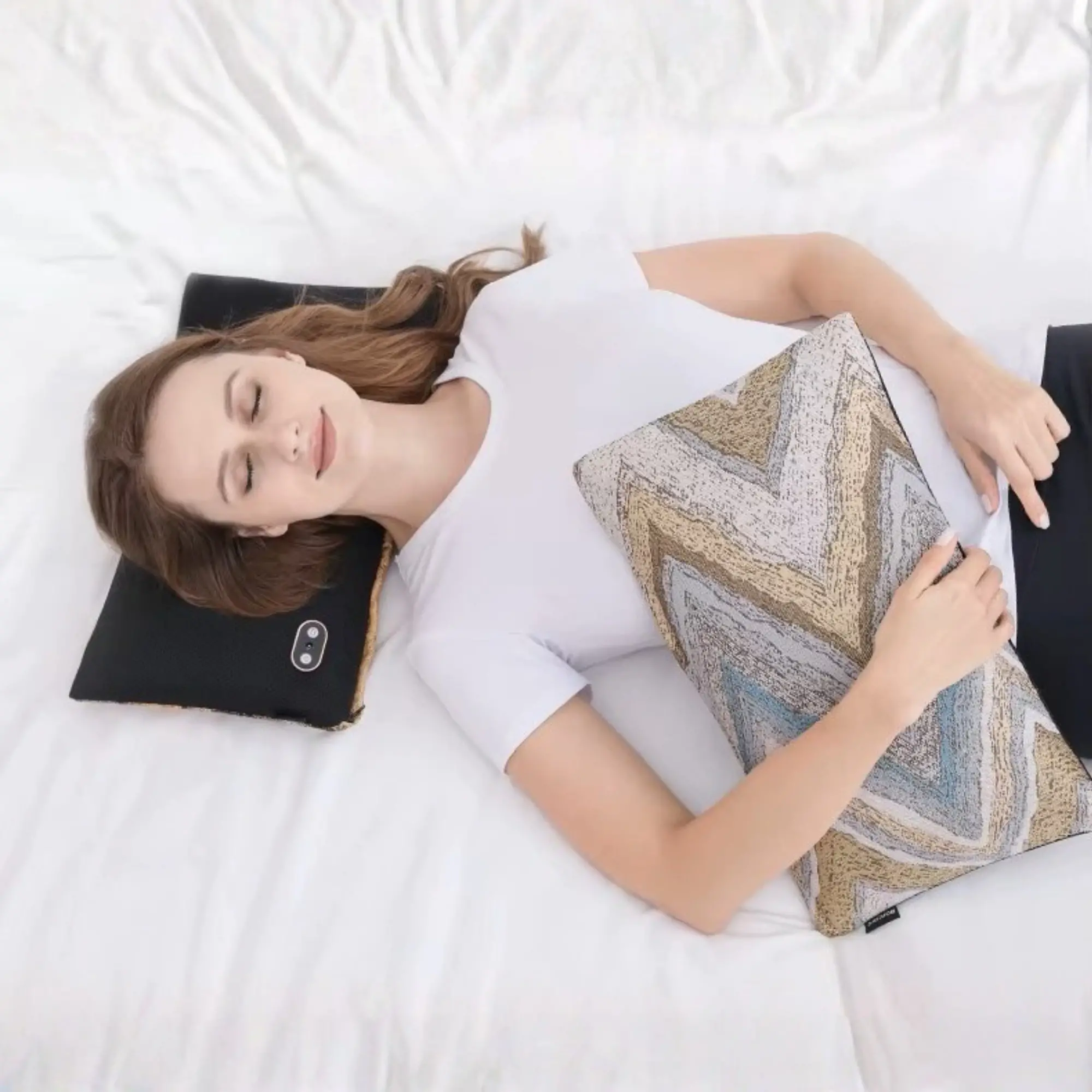 Femme profitant d'un massage avec le coussin Relaxo sur un lit